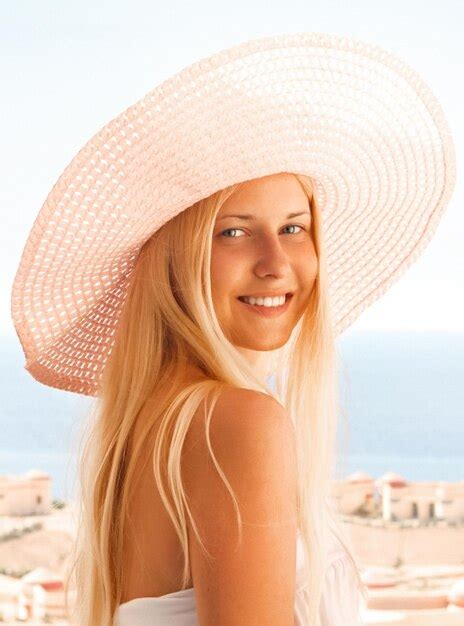 Premium Photo Woman With Blond Hair Wearing Hat Enjoying Seaside And Beach Lifestyle In