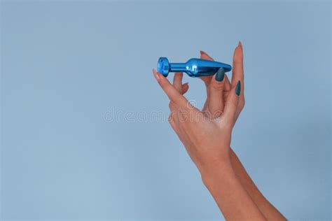 Woman Holds Blue Sex Toy In Hands In The Studio Conveption Of Intimacy