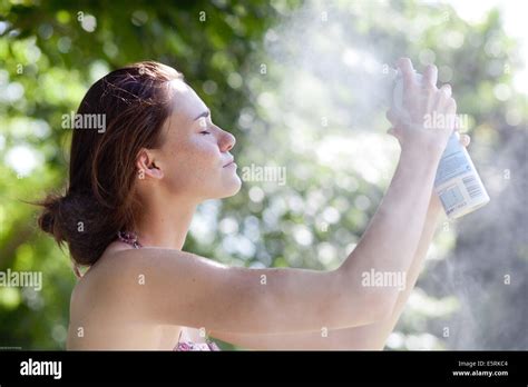Woman Spraying Water On Her Face Stock Photo Alamy