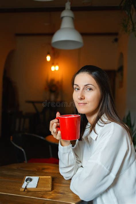 Red Cup Of Coffee In The Hands Of A Beautiful Smiling Girl Stock Photo