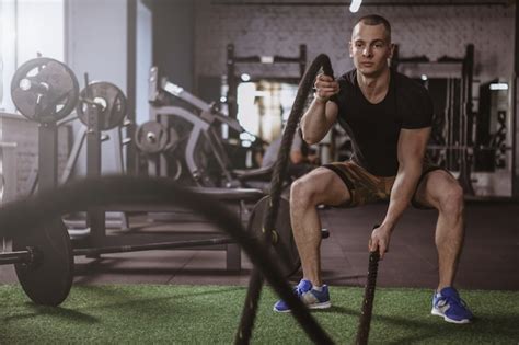 Premium Photo Male Crossfit Athlete Working Out With Battle Ropes At Gym