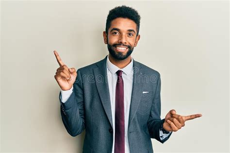 Handsome Hispanic Man With Beard Wearing Business Suit And Tie Smiling Confident Pointing With