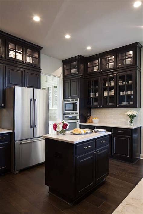 Using your wall space for storage is a great way to accomplish both of your goals. Black KItchen Cabinets with Glass Front Doors That Go All ...