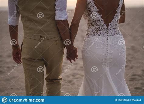 Horizontal Shot Of A Bride And Broom Holding Each Other S Hands In The