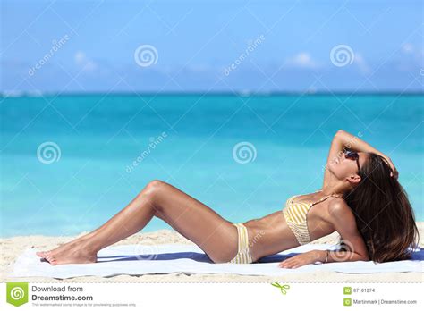 Femme De Bronzage Obtenant Un Bronzage De Bikini Sur La Plage Photo