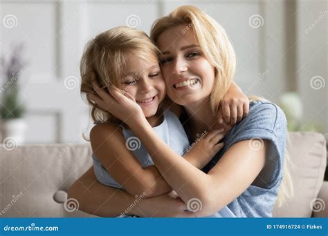Portrait Of Happy Young Mom And Little Daughter Cuddling Stock Photo
