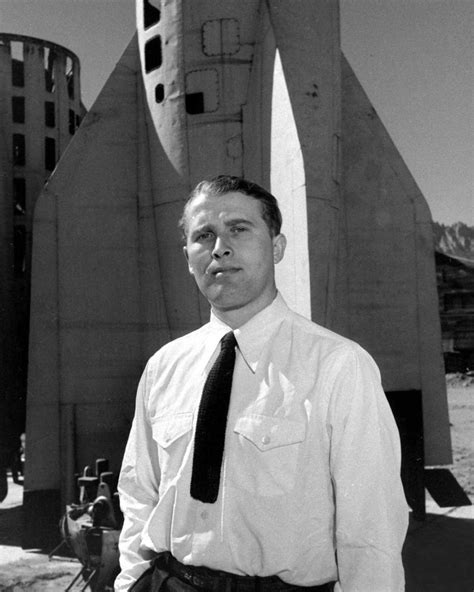 Wernher von Braun stands in front of a V-2 rocket at White Sands, New