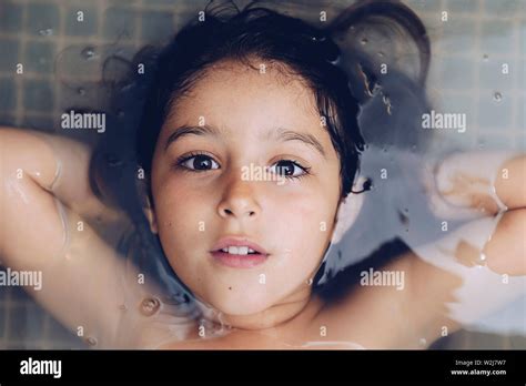Retrato De Una Hermosa Niña Feliz Tumbado En La Bañera Mientras Toma Un