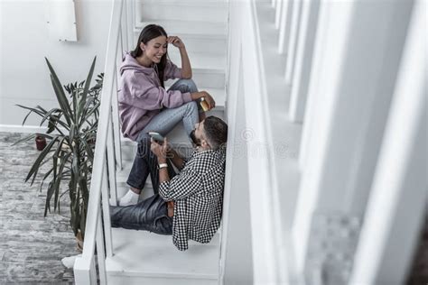 Cute Loving Couple Having Conversation At Home Sitting On Stairs Stock