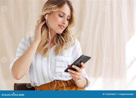 Image Of Gorgeous Elegant Blonde Woman In Earphones Holding Smartphone
