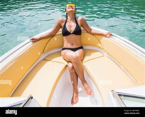 Woman Sunbathing At The Bow Of A Motor Boat At A Tropical Island Stock