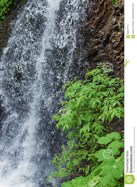 A Stream In The Mountains Flows Along The Rocks And A Stormy Waterfall
