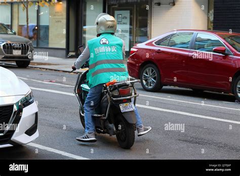 A Fantuan food delivery person on an electric moped in New York City