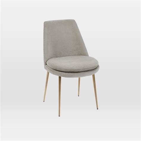 Looking at the chair from the front, it's much deeper and more narrow than it appears, imbuing it with a kind of sneaky coziness. Finley Low-Back Velvet Dining Chair | west elm UK