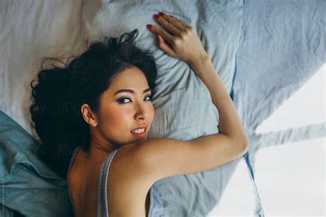 Woman Hugging Pillow And Looking At Camera By Stocksy Contributor