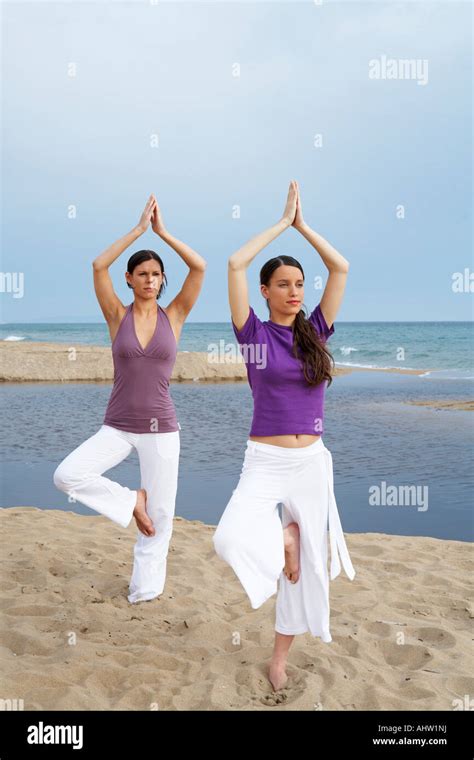 Two Women Doing Yoga On Beach Stock Photo Alamy
