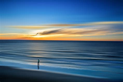 Person Standing On Seashore Under Blue Sky Hd Wallpaper Wallpaper Flare
