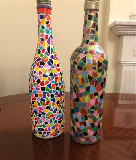 Two Colorful Glass Bottles Sitting On Top Of A Wooden Table Next To