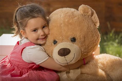 Portrait Of Expressive Little Girl Hugging Her Toy Bear Stock Photo