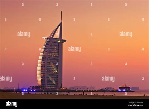 Dubai Burj al Arab hotel with sunset lit up at night Dubai, United Arab