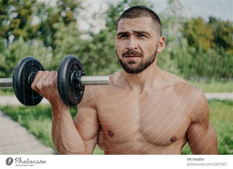 Serious Sportsman Poses With Naked Torso Has Muscular Body Raises Dumbbell Poses Outdoor Being
