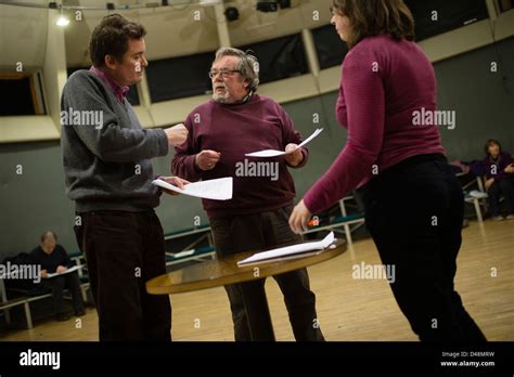 A Director With His Actors In Rehearsal Holding Their Scripts Reading