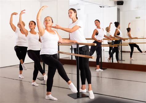 European Female Ballet Teacher Showing Moves In Front Of A Group Of