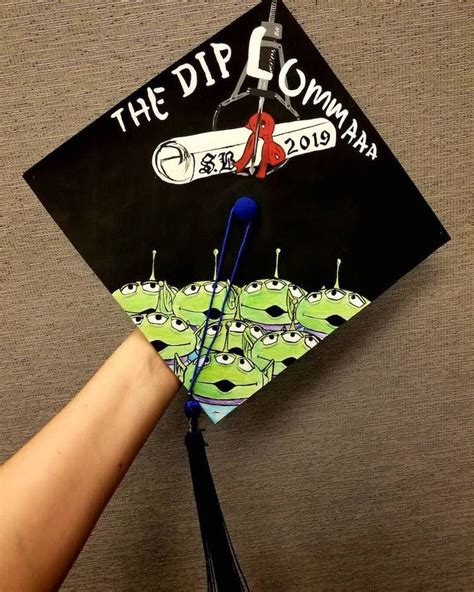 A Graduation Cap With The Words The Dip Comma Written On It Is Being Held By A Person S Hand
