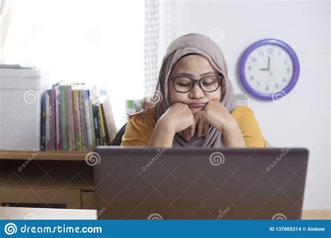Tired Sleepy Muslim Businesswoman Waiting In Front Of Her Laptop Stock