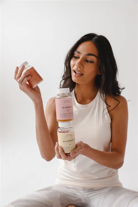 A Woman Sitting On The Floor Holding A Jar Of Skin Care Products In Her Hand