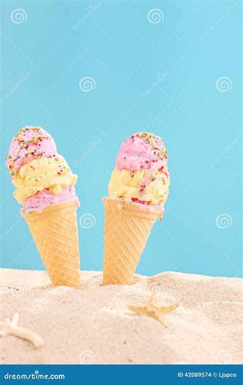 Vertical Shot Of Two Ice Creams Stuck In Sand Stock Photo Image Of