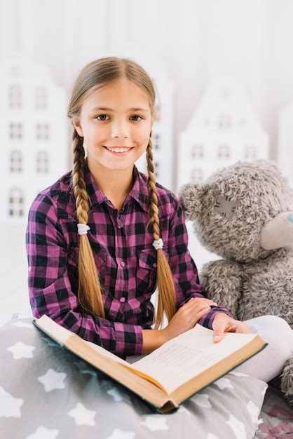 Niña Pequeña Adorable Leyendo Un Libro Con Su Osito De Peluche Foto