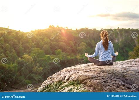 Yoga Woman Sit In Meditation Pose On Mountain Peak Rock At Sunrise