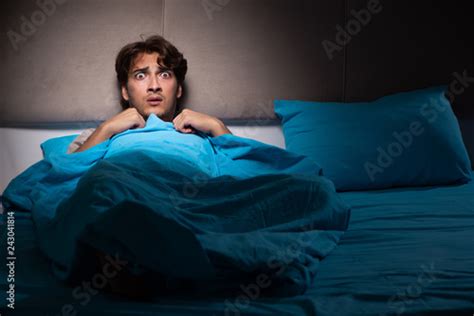 Young Man Scared In His Bed Having Nightmares Buy This Stock Photo