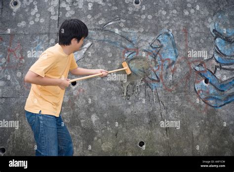 Young Man Cleaning Graffiti On Wall Stock Photo Alamy