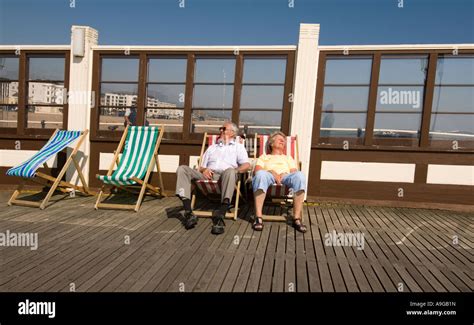 Mature Couple Sitting In Deck Chairs On Worthing Pier Stock Photo Alamy