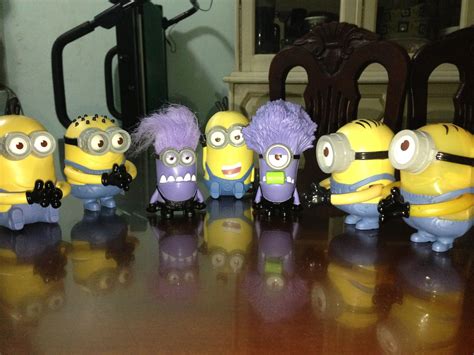 A Group Of Minion Figurines Sitting On Top Of A Table