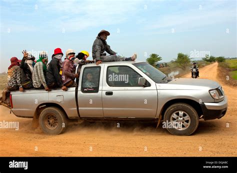 Small Pickup Truck Carrying Farm Workers In The Crowded Cargo Bay On A