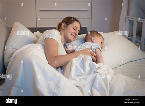 Portrait Fo Smiling Young Mother Lying In Bed With Her 9 Months Old