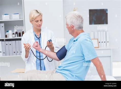 Doctor Checking Senior Mans Blood Pressure Stock Photo Alamy