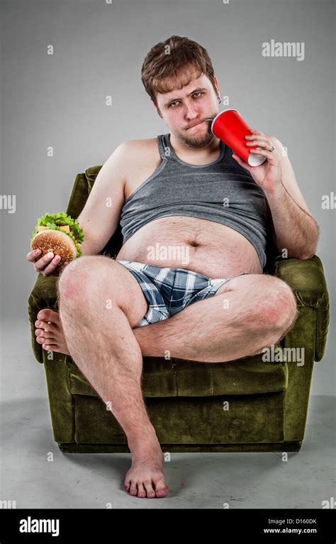Fat Man Eating Hamburger Seated On Armchair Stock Photo Alamy