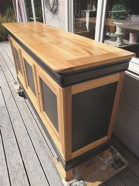 A Large Wooden Counter Sitting On Top Of A Wooden Floor Next To A Building Window