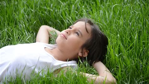 Cute Kid Lying On The Beautiful Green Grass Summertime Relaxing Stock