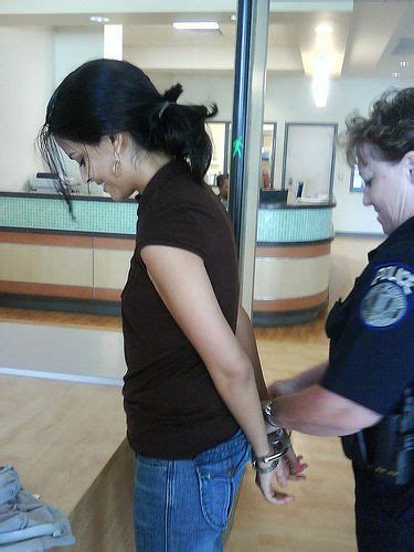 Young Woman Smiles While She Gets Handcuffed Behind Back At A Polices