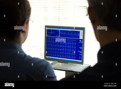 Doctors Reviewing On A Computer Monitor An Electrocardiogram Recording
