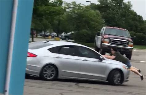 Video Shows Woman Clinging To Hood Of Fleeing Shoplifting Suspects Car