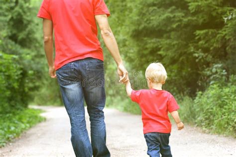 Padre E Hijo Que Llevan A Cabo Las Manos En El Parque Imagen De Archivo