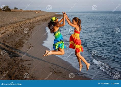 Dwa Szczęśliwej Małej Dziewczynki Skacze W Powietrzu Na Plaży Obraz