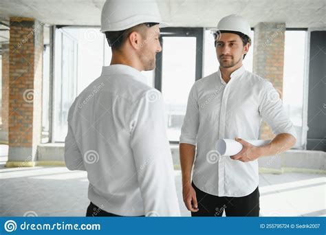 Male Architect Giving Instructions To His Foreman At Construction Site