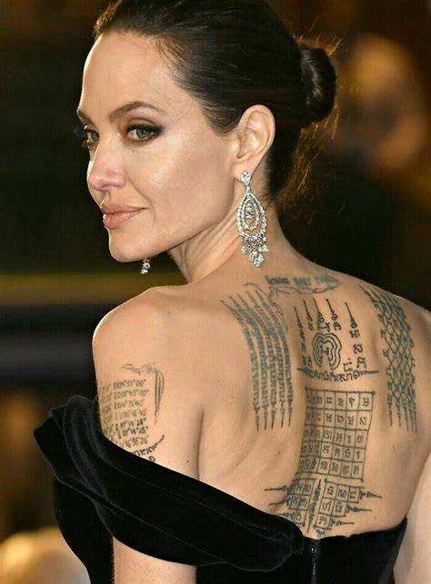 the back of a woman s neck with tattoos on her chest and shoulder